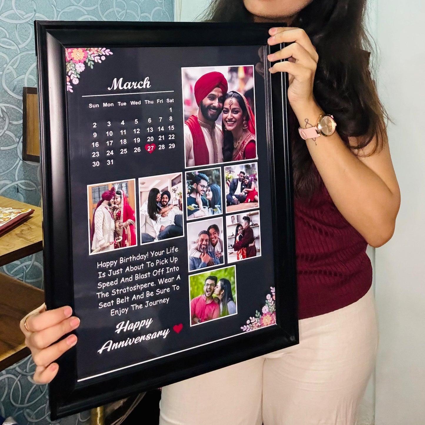 Woman holding a framed calendar with multiple photos and text